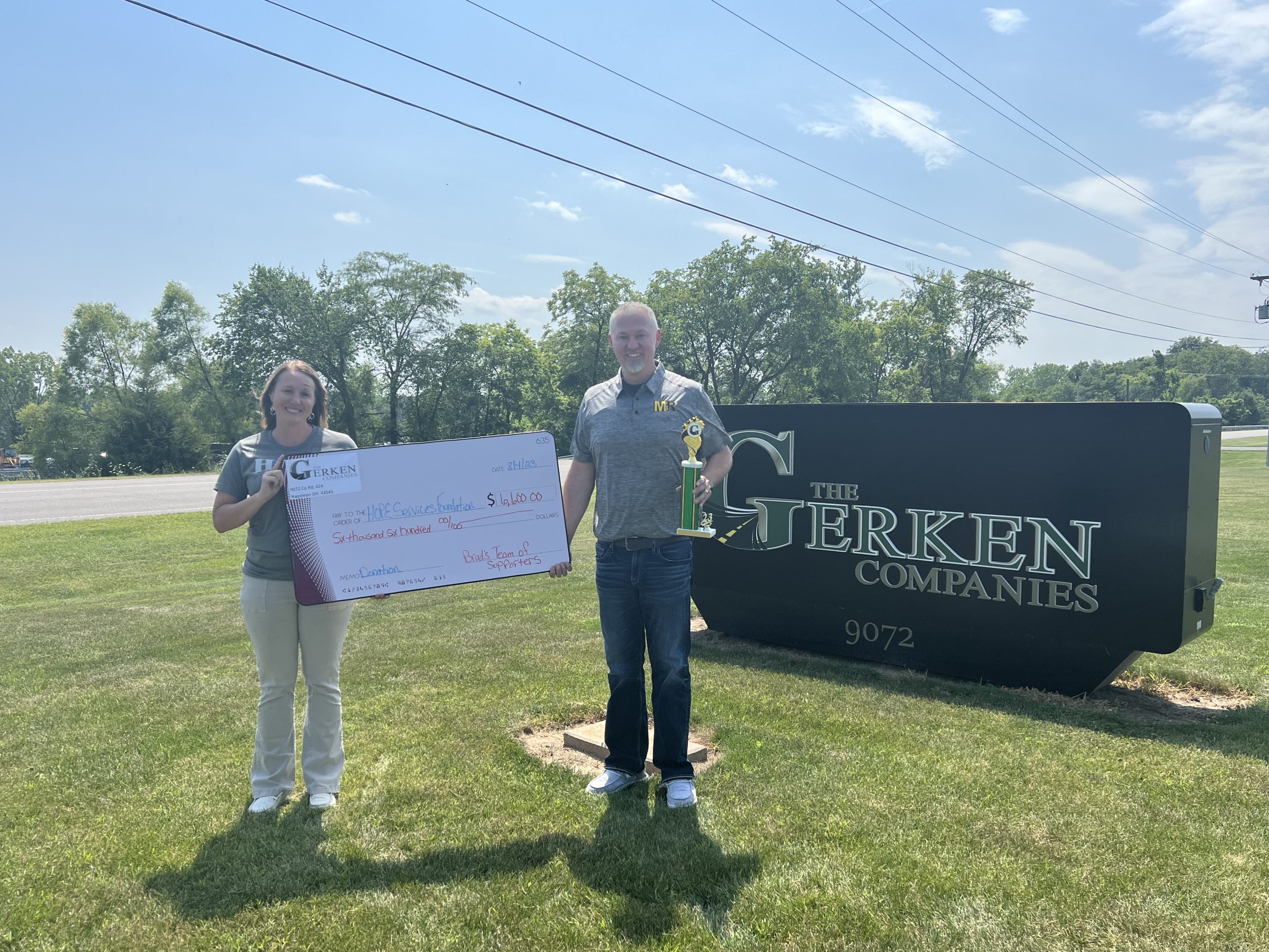 Kelly Aldrich, Superintendent with Hope Services (left), accepting the $6,600 donation from Brad Rittenhouse of M&R Ready Mix